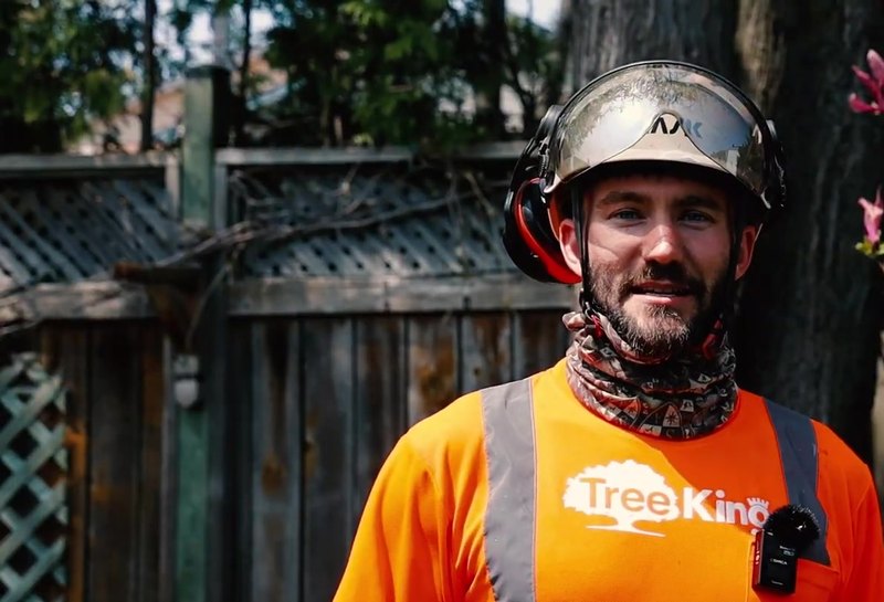 Jerome, ISA Certified Arborist with Tree King, in front of a flowering magnolia