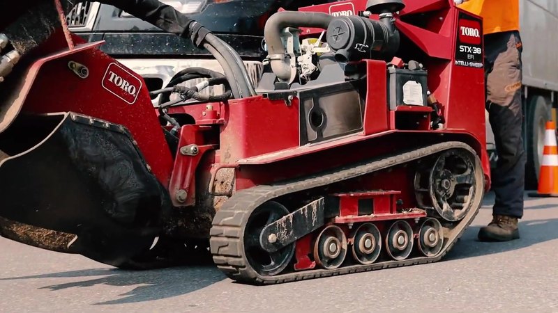 Red tracked stump grinder on a driveway, ready for stump grinding